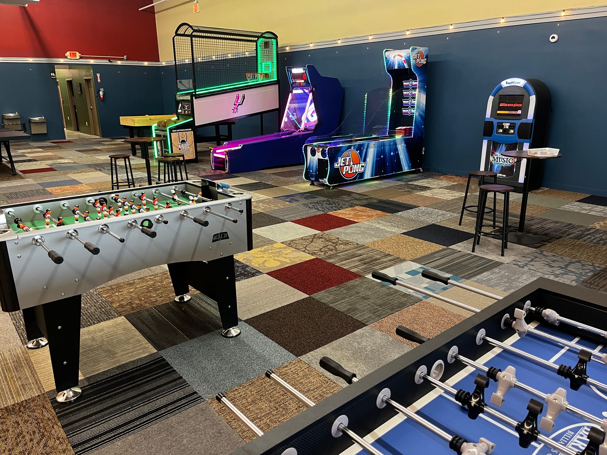 Rows of lit arcade cabinets in the Hawk's Nest game room